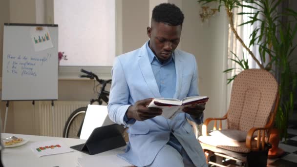Focused Intelligent African American Man Reading Book Turning Pages Leaning — Stockvideo