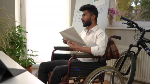 Yakışıklı Ortadoğulu Zeki Kucaklaşma Kitabı Okuyan Gülümseyen Tekerlekli Sandalyede Oturan — Stok video