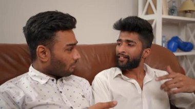İki kaygısız Orta Doğulu adam oturma odasında rahat bir kanepede oturup şarkı söylüyor. Mutlu yakışıklı arkadaşlar hafta sonları evde eğleniyorlar.