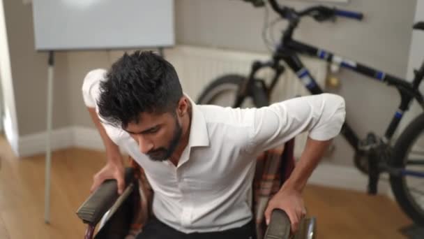 車椅子から立ち上がろうとする若い男を動機とした 自宅で事故の後に回復ハンサムな中東の男の肖像画 リハビリテーションと健康の概念 — ストック動画