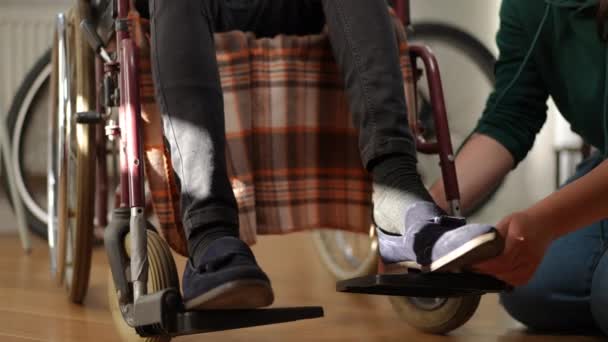 Unrecognizable Caucasian Woman Putting Shoes Feet Man Sitting Wheelchair Loving — Vídeo de Stock