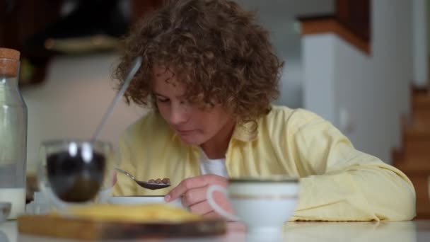 Curly Haired Cute Boy Eating Morning Cereal Sitting Table Indoors — Stock Video