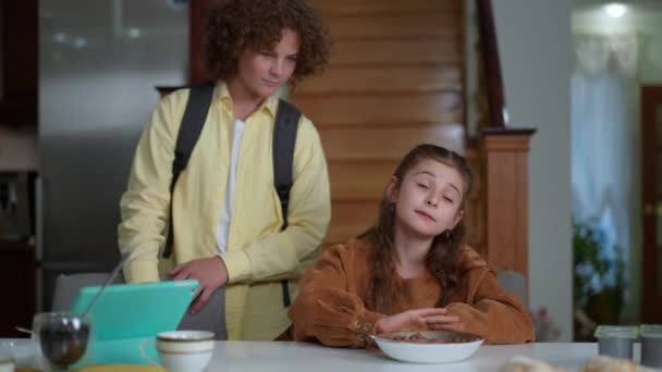 Beautiful Caucasian Girl Refusing Eating Breakfast Cereal Smiling Boy Talking — Stockvideo