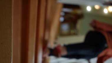 Vertical video of wooden stairs with blurred unrecognizable Caucasian mother son and daughter walking downstairs. Confident woman boy and girl leaving to work and school in the morning