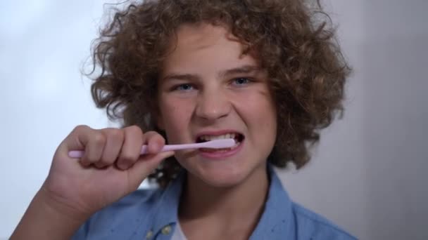 Вид Спереди Симпатичного Мальчика Чистящего Зубы Смотрящего Камеру Зубастой Улыбкой — стоковое видео