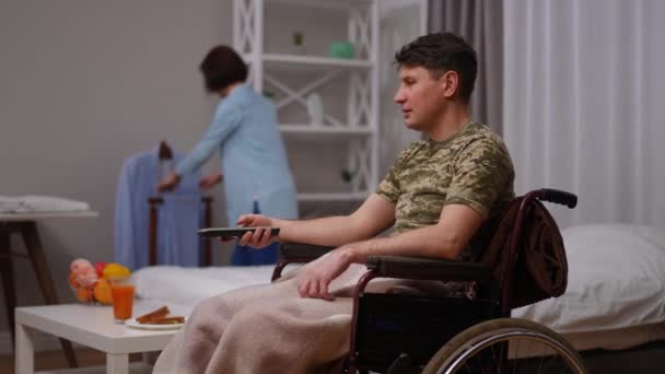Widok Boku Żołnierz Wózku Inwalidzkim Oglądanie Przełączanie Kanałów Pilotem Jako — Wideo stockowe