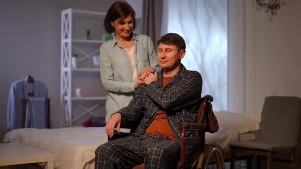 Man Pajamas Sitting Wheelchair Holding Hand Loving Woman Shoulder Looking — ストック動画