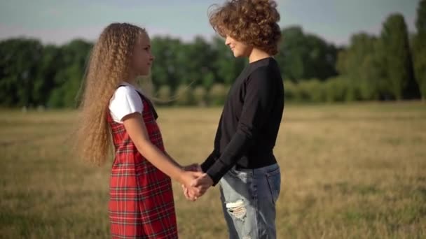 Side View Smiling Caucasian Boy Girl Holding Hands Standing Outdoors — Vídeo de Stock