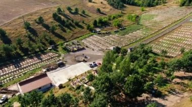 Snail farm in sunrays with agricultural fields and forests at background. Wide shot aerial view spring summer landscape outdoors in sunshine