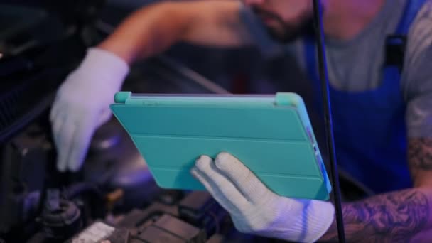 Detailní Digitální Tablet Ruce Rozmazaného Mladého Automechanika Kontrolujícího Vozidlo Garáži — Stock video