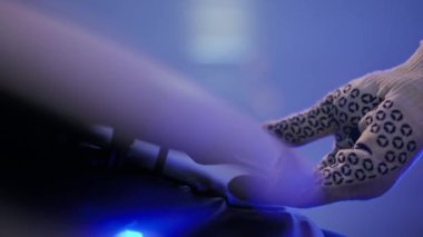 Close-up male hand opening car hood at service station. Side view vehicle with unrecognizable Caucasian young man in gloves fixing failure