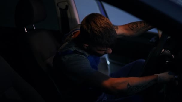 侧视聚焦的男人在制服起动汽车发动机坐在司机的座位上 集中的高加索青年汽车技师检查车维修后在加油站 — 图库视频影像