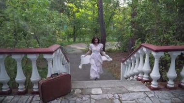 Live camera follows joyful slim young retro lady running upstairs to door on porch. Happy confident Caucasian redhead woman in vintage dress returning home