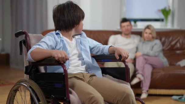 Sfrustrowany Białas Wózku Inwalidzkim Spoglądający Wstecz Smutnych Rodziców Wzdychający Przed — Wideo stockowe