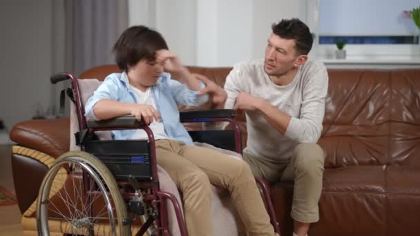 Tekerlekli Sandalyedeki Sinirli Çocuk Babasının Oturma Odasından Uzaklaşmasını Reddediyor Kafkasyalı — Stok video