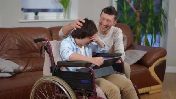 Tekerlekli Sandalyedeki Gülen Çocuk Saçlarını Okşayan Kol Hareketi Yapan Adamla — Stok video