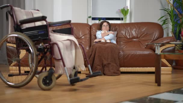 Široký Záběr Smutný Chlapec Objímající Hračku Sedící Gauči Rozmazaným Invalidním — Stock video