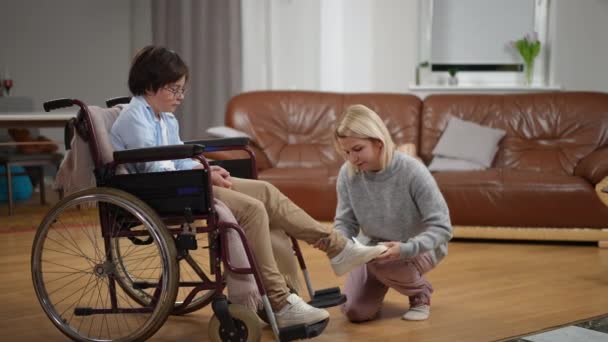 Geniş Açılı Sevgili Anne Tekerlekli Sandalyede Yürüyen Hasta Oğluna Ayakkabı — Stok video
