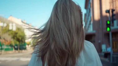 Arkadan bakan, nakışlı Ukrayna giysileri içinde genç bir kız. Şehir caddesinde yürüyor ve ağır çekimde etrafa bakıyor. Kendine güvenen esmer ergen şehir dışında geziniyor.