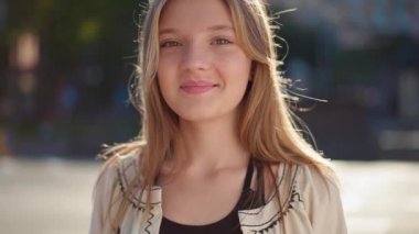 Geleneksel Ukrayna işlemeli tişörtlü mutlu genç kızın portresini büyüt. Gün ışığında kameraya bak. Gülümseyen güzel genç şehir sokaklarında ağır çekimde poz veriyor.