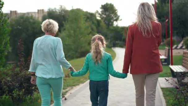 Seuranta Laukaus Valkoihoinen Tyttö Kädestä Äiti Isoäiti Kävelee Ulkona Back — kuvapankkivideo