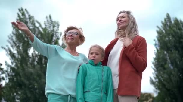 Abuela Sonriente Señalando Lejos Sonriendo Pie Con Hija Nieta Aire — Vídeo de stock