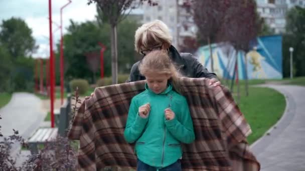 Прекрасна Сірувата Жінка Покриває Дівчину Ковдрою Обіймаючи Дитину Стоїть Надворі — стокове відео