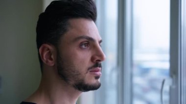 Hastanenin penceresinden dışarı bakan konsantre olmuş Orta Doğulu bir adamın yüzü. Tıp kliniğindeki yakışıklı, zeki erkek doktor. Yavaş çekim