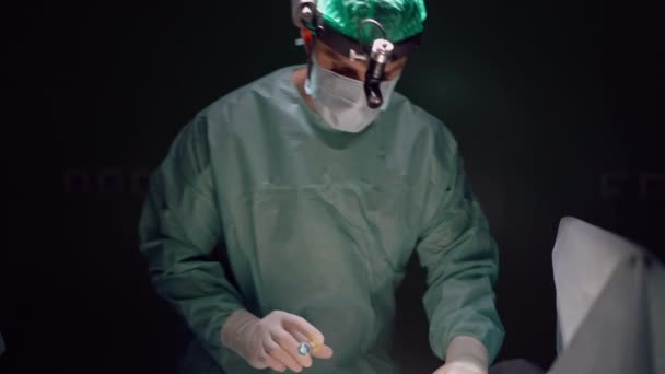 前视中镜头聚焦外科医生注射麻醉与注射器慢动作 机灵的中东人 身穿制服 戴着面具 在手术室里集中精神 — 图库视频影像