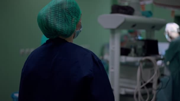 Νοσοκόμα Στολή Που Στέκεται Στο Χειρουργείο Θολή Συναδέλφους Κοιτάζουν Αργή — Αρχείο Βίντεο