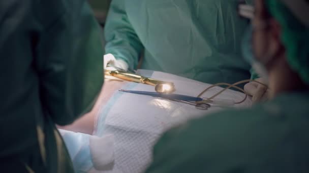 专业外科医生和护士在缓慢运动的情况下进行隆胸手术的肩部后空翻 手术室手术台上一个无法辨认的女人拿着工具 — 图库视频影像