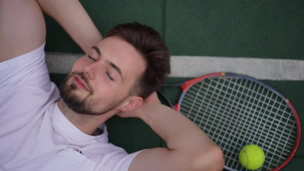 Close Bovenaanzicht Lachend Tevreden Sportman Liggend Groene Baan Met Tennisracket — Stockvideo