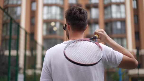 Sırtüstü Uzanan Tenis Raketiyle Spor Sahasında Ağır Çekimde Yürüyen Genç — Stok video