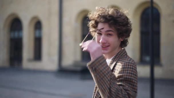 Neşeli Adam Kameraya Bakıp Güneş Gözlüğünü Çıkarıyor Şehrin Sokaklarında Gülümseyen — Stok video