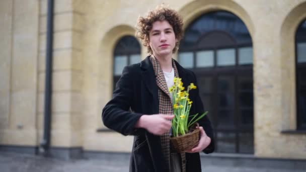 Knappe Man Die Pot Uitrekt Met Gele Bloemen Die Naar — Stockvideo