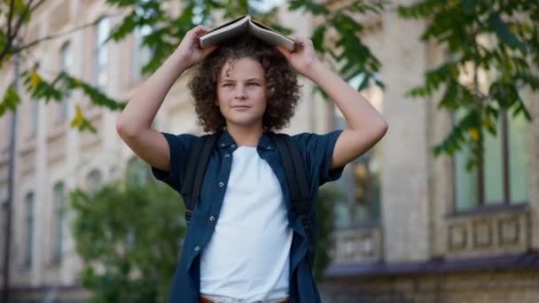 Portrait Positive Confident Boy Putting Book Head Looking Standing Outdoors — Stock Video