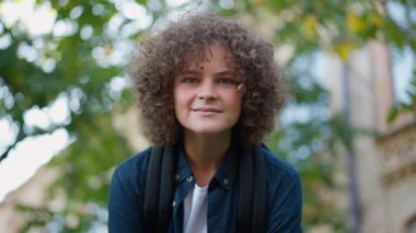 Açık havada kameraya bakan pozitif gülümseyen okul çocuğunun portresi. Okul bahçesinde yavaş çekimde poz veren kendinden emin beyaz çocuk. Eğitim ve yaşam tarzı kavramı