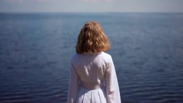 Arkadaki Beyaz Elbiseli Kız Mavi Nehir Dalgalarının Arka Planında Duruyor — Stok video