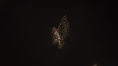 Kuş şeklindeki yan görüş ışıkları siyah gökyüzündeki rahibin resmine dönüşüyor. Gece açık havada lazer gösterisi.