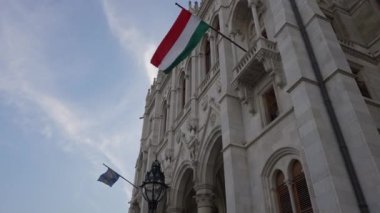 Budapeşte, Macaristan - 16 Mayıs 2022: Macaristan Parlamento Binası 'nda dalgalanan Szekelyler' in ulusal bayrağı. Şehir caddesindeki antik Gotik bina sembollerle dolu.