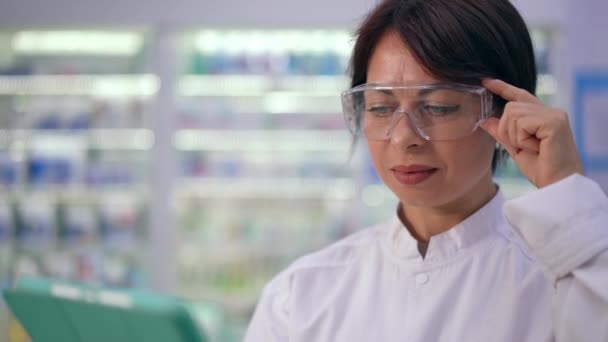 Сосредоточенная Женщина Защитных Очках Цифровым Планшетом Аптеке Помещении Живая Камера — стоковое видео