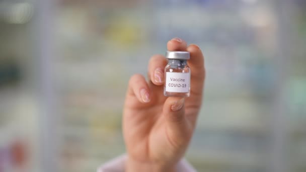 雌性白种人手部特写镜头中的考罗那韦疫苗罐 无法辨认的年轻自信女子手握病毒疗法溶液在室内 慢动作 — 图库视频影像