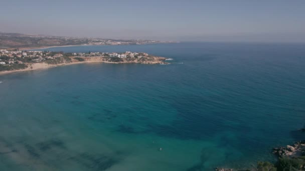 春の夏の日にキプロスの広いショット紺碧の青い地中海の海の湾 屋外の穏やかな観光リゾートからドローンビューズームアウトします 旅と静けさのコンセプト — ストック動画