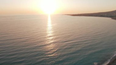 Kıbrıs 'ta gün batımında Akdeniz dalgaları üzerinde güneş yolu. Gün batımında adanın sakin ve güzel manzarası.