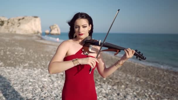 太陽の下で屋外で音楽を楽しむバイオリンを演奏白人の自信に満ちた女性の中出し 地中海沿岸の日差しの中で才能豊かな吸収音楽家の肖像画 — ストック動画
