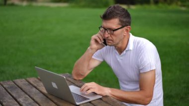 Akıllı, konsantre bir adamın portresi iş planını tartışıyor, internette internette internette geziniyor. Yüksek açı görüşlü, gözlüklü, bağımsız beyaz tenli. Yavaş çekim