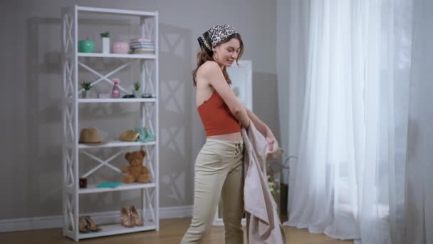 Krásná Žena Svléká Kabát Usmívá Kameru Která Otáčí Obývacím Pokoji — Stock video