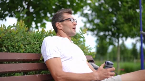 Retrato Homem Caucasiano Adulto Satisfeito Óculos Olhando Redor Sentado Banco — Vídeo de Stock