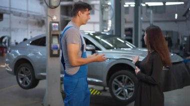 Uzman bakım mühendisinin, müşteriyle el sıkışarak yavaş çekimde ayrılırken çekilmiş bir portresi. Kafkasyalı profesyonel bir adam ve genç bir kadın kapalı mekanda servis yapıyor.