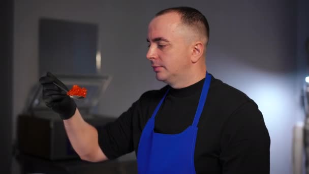 Zijaanzicht Geconcentreerde Man Onderzoekt Rode Kaviaar Lepel Staan Keuken Binnen — Stockvideo